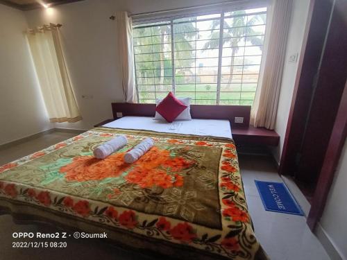 a bedroom with a bed with two pillows on it at Sunderban Tiger Residency in Gosāba