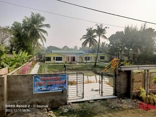 a house with a sign in front of a gate at Sunderban Tiger Residency in Gosāba