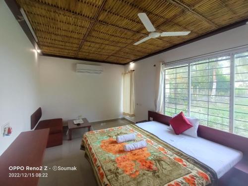 a bedroom with a bed and a ceiling fan at Sunderban Tiger Residency in Gosāba