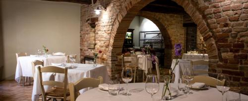 a room with tables and chairs with white table linen at Ca' Virginia Country House Wellness in Montecalvo in Foglia