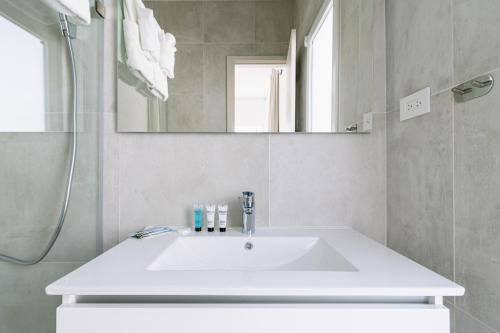uma casa de banho com um lavatório branco e um espelho. em Caya Erasmus 20 em Tanki Lender