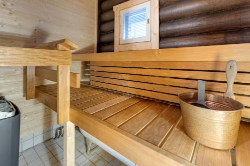 a sauna in a wooden cabin with a bucket at Alppirinne - Tunnelmallinen loma-asunto Suomulla in Suomutunturi