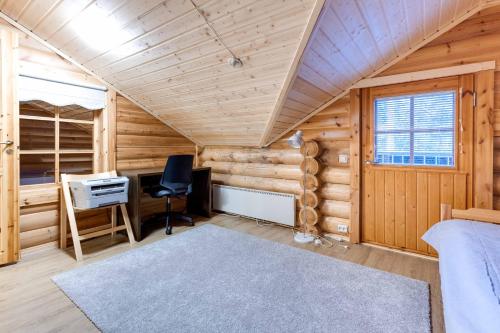 a log cabin office with a desk and a chair at Holiday Apartment Alppirinne in Suomutunturi