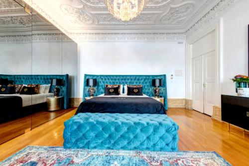 una camera con letto blu e lampadario a braccio di 1877 Estrela Palace ad Aveiro