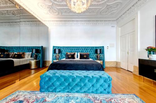 a bedroom with a blue bed and a chandelier at 1877 Estrela Palace in Aveiro