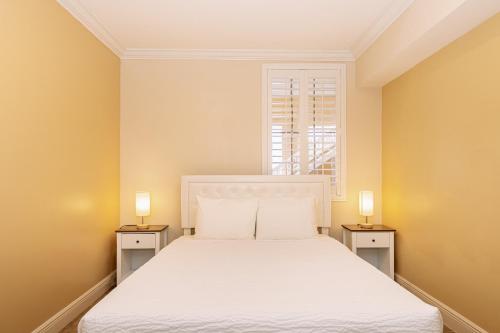 a bedroom with a white bed with two night stands at Divi Village Condo 31 in Palm-Eagle Beach