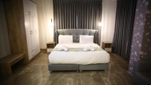 a bedroom with a large bed with a blue headboard at Lotus Boutique Hotel in Bethlehem