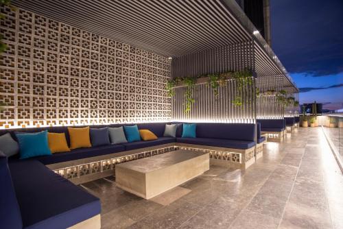 a patio with a blue couch and a table at voco Guadalajara Neruda by IHG in Guadalajara