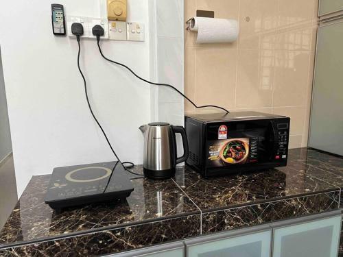 eine Küchentheke mit einer Mikrowelle und einem Toaster in der Unterkunft M Guest House2 in Muar