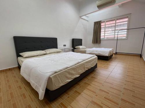 a large bedroom with two beds and a window at M Guest House2 in Muar