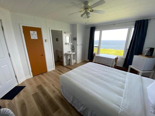 a bedroom with a large bed and a large window at Restaurant-Motel L'Etoile du Nord in Pointe a la Fregate