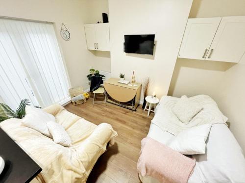 ein Wohnzimmer mit einem Sofa und einem Tisch in der Unterkunft Townhouse close to Liverpool City Centre - 5 bedrooms, Sleeps 9! in Liverpool