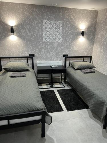 a bedroom with two beds and a side table at Avto Spa in Khmelʼnytsʼkyy