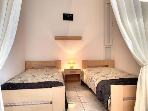 two beds in a small room with a window at Studio Balaruc-les-Bains, 1 pièce, 4 personnes - FR-1-503-41 in Balaruc-les-Bains