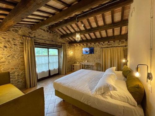 a bedroom with a large bed in a brick wall at Ca' Virginia Country House Wellness in Montecalvo in Foglia