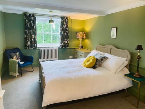 1 dormitorio con 1 cama, 1 silla y 1 ventana en Stunning Countryside Home with Hot Tub - Sleeps 8, en Thurgarton