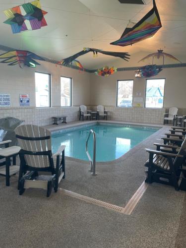 una piscina con sedie e aquiloni appesi al soffitto di Boothill Inn and Suites a Billings