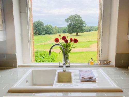 a kitchen sink with a window with a vase of flowers at Stunning Countryside Home with Hot Tub - Sleeps 8 in Thurgarton