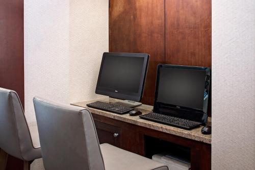 a desk with two monitors and a laptop on it at Hyatt Place Pittsburgh North Shore in Pittsburgh
