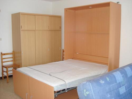 - une chambre avec un lit, deux placards et une chaise dans l'établissement Appartement avec balcon, parking, clim et animaux admis proche des Thermes - FR-1-503-18, à Balaruc-les-Bains