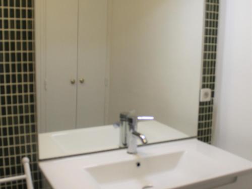 une salle de bain avec un lavabo et un miroir dans l'établissement Appartement *** à Balaruc-les-Bains: Proche Thermes, Équipé, Balcon, Parking - FR-1-503-111, à Balaruc-les-Bains