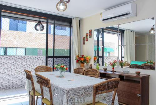 a dining room with a table and chairs at Apartamentos na Orla da Pajuçara in Maceió