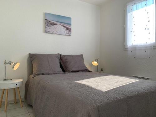 une chambre avec un lit, une table et une fenêtre dans l'établissement Appartement climatisé à Balaruc-les-Bains avec balcon, parking et animaux admis - FR-1-503-127, à Balaruc-les-Bains