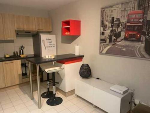 une cuisine avec une table et un bus rouge sur le mur dans l'établissement Studio Agora, à Douvaine
