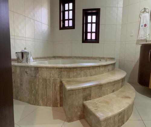 a bathroom with a large tub in a room at Casa alto padrão in Cascavel