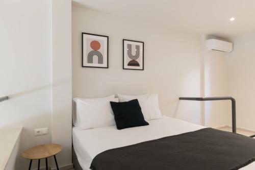 ein weißes Schlafzimmer mit einem Bett und einem Stuhl in der Unterkunft Voda Luxury Residence #002 in Athen