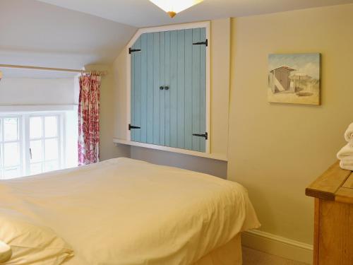 a bedroom with a bed and a blue cabinet at Georges Cottage - Hsss in Clovelly