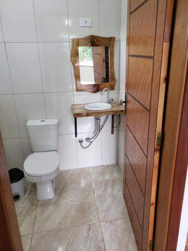 a small bathroom with a toilet and a sink at Chácara do Picapau Amarelo in Socorro