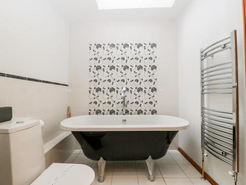 uma casa de banho com banheira e WC em The Granary em Chepstow