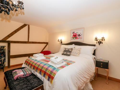 um quarto com uma cama grande e lençóis brancos em The Granary em Chepstow