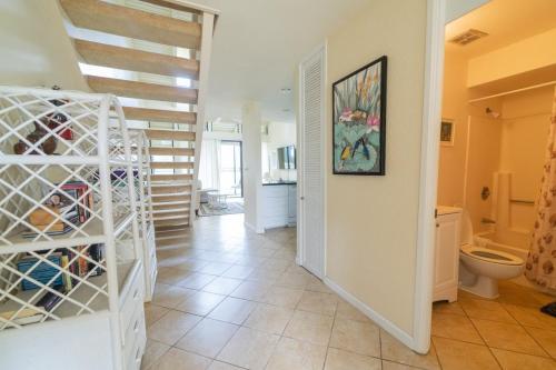 a hallway with a toilet and a staircase in a house at Bird of Paradise Condo in Kahuku