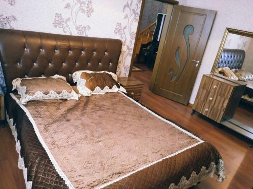 ein großes Bett in einem Zimmer mit einem braunen Kopfteil in der Unterkunft Gabala red villa in Qəbələ