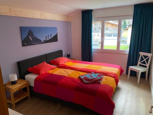 ein Schlafzimmer mit einem Bett mit einer bunten Decke in der Unterkunft Spring Inn Apartments in Meiringen