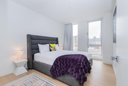 a bedroom with a bed and a large window at Le Se7t Penthouses in Montréal