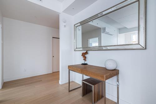 a mirror on a wall above a wooden table at Le Se7t Penthouses in Montréal