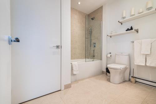 a bathroom with a toilet and a shower and a sink at Le Se7t Penthouses in Montréal