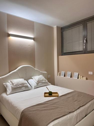 Fiera Milano City Apartment في ميلانو: غرفة نوم بسرير ابيض ونافذة