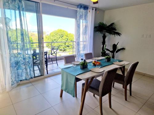 a dining room with a table and chairs and a balcony at OASIS Penthouse with private garden & shared pool in Koolbaai