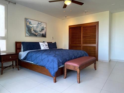 1 dormitorio con 1 cama y ventilador de techo en OASIS Penthouse with private garden & shared pool, en Koolbaai