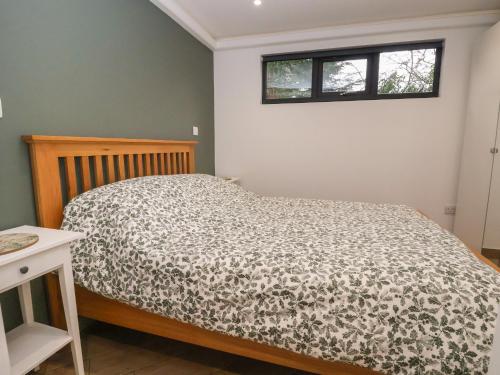 um quarto com uma cama com um edredão e uma janela em The Nest em Prestatyn