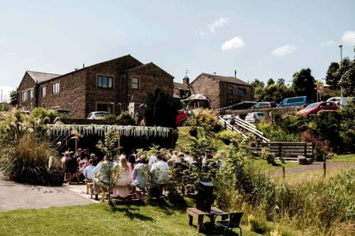a group of people sitting in the yard of a house at Grains Bar Hotel in Oldham