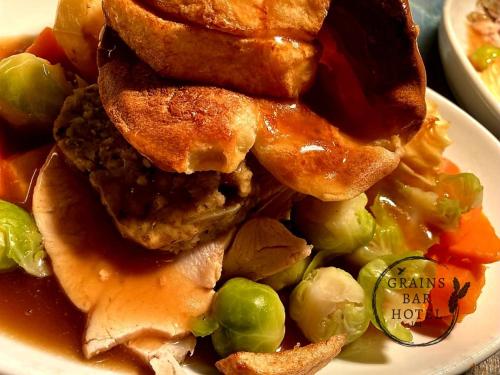 a plate of food with a sandwich and vegetables at Grains Bar Hotel in Oldham