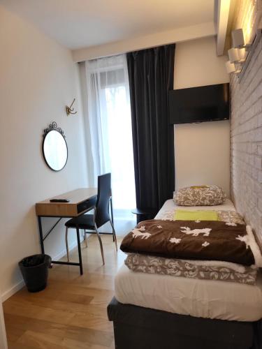 a bedroom with a bed and a desk and a table at Amber Hostel Szlak in Krakow