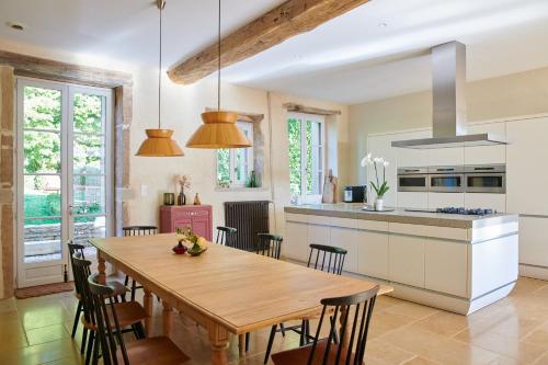 une cuisine et une salle à manger avec une table et des chaises en bois dans l'établissement Maison Laroze, à Gevrey-Chambertin