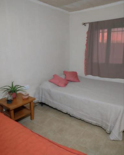 1 dormitorio con 2 almohadas rojas en una cama en Hospedaje Los Girasoles en Salto de las Rosas