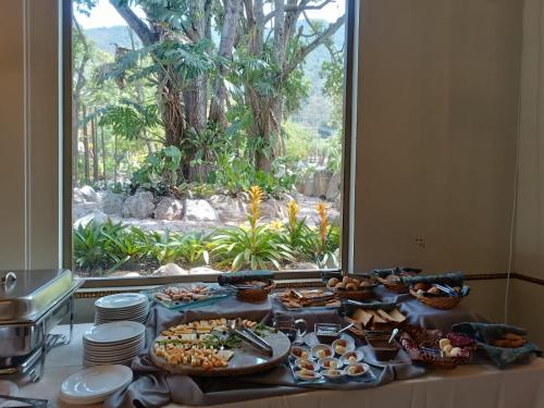 a buffet of food on a table in front of a window at Uzhupud Garden Hotel & Lodge in Paute